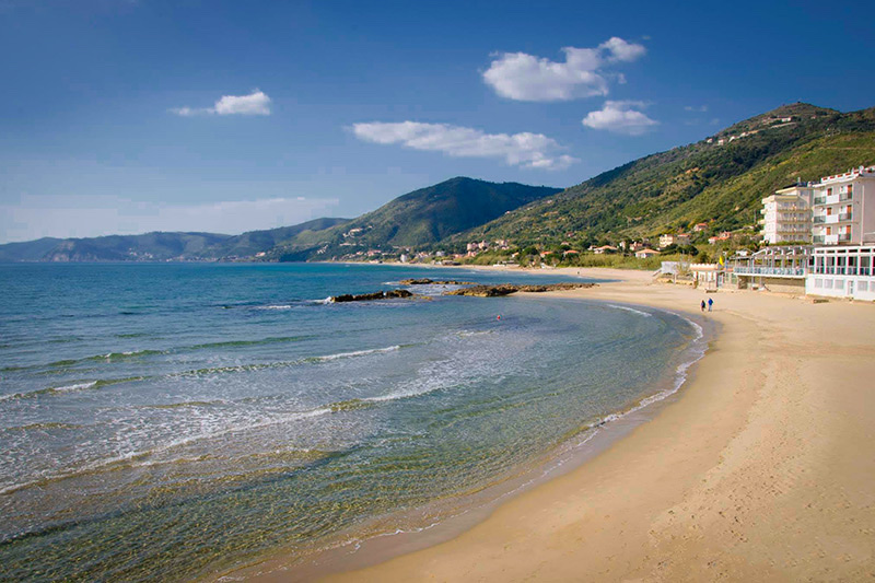 La spiaggia sabbiosa di Acciaroli con il mare limpido e le colline del Cilento